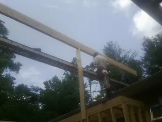 Carpenter setting a ridge beam over a new addition frame — Ice Dam Removal by Roofing Brothers in South Butler