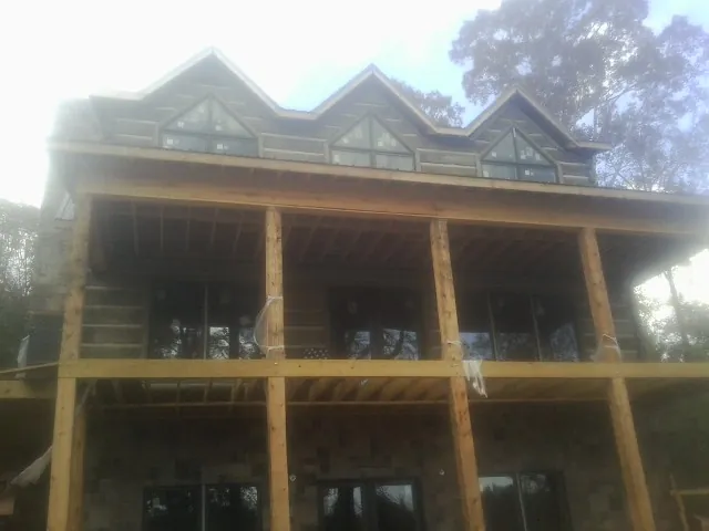 Dormers and porch framing on a large log home under construction — Roof Coating work by our crew in South Butler