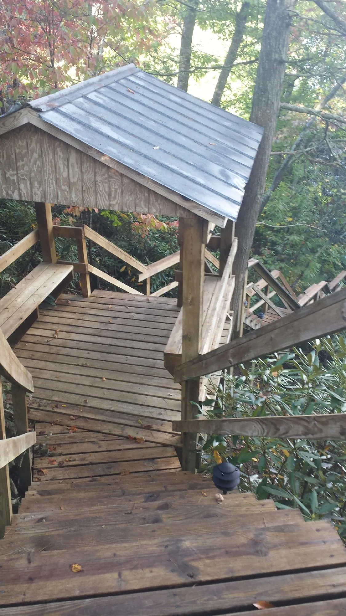 Metal roofed shelter over wooden steps on a wooded walkway — Skylight Repair & Installation work by our crew in South Butler