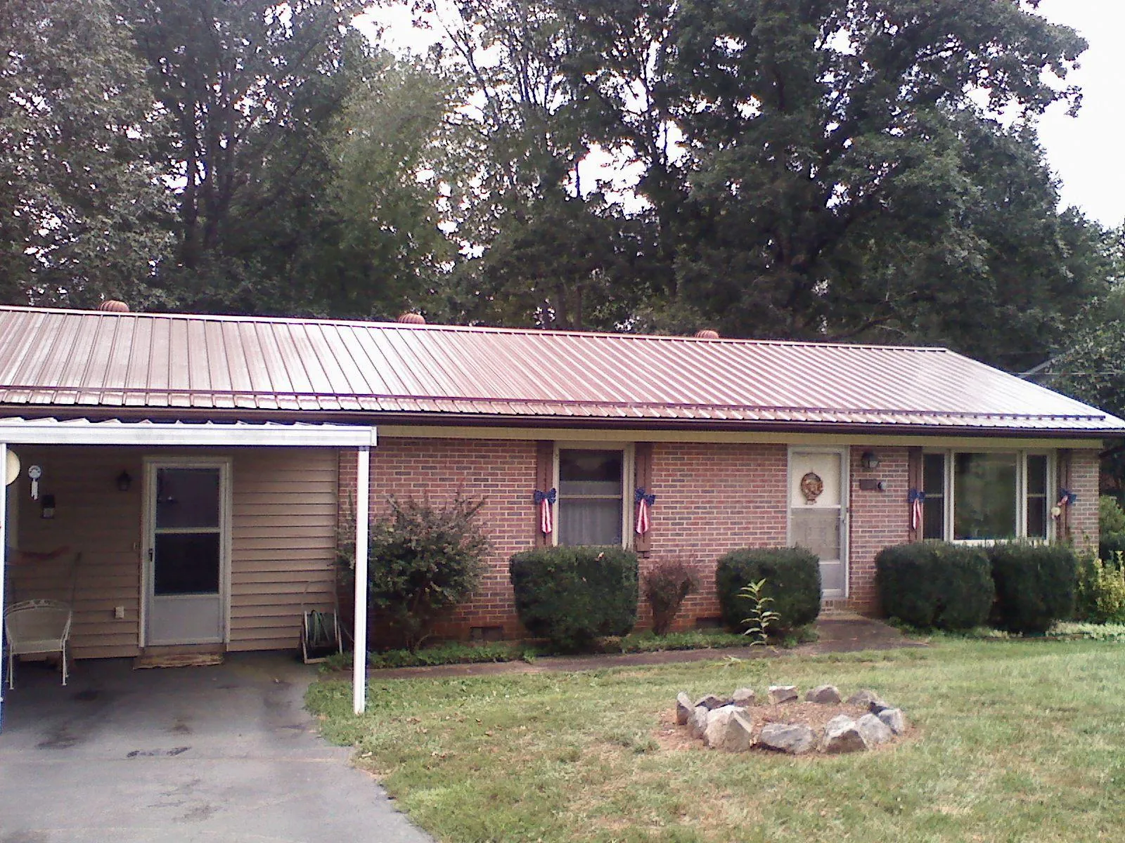 Bronze metal roof and carport on a brick ranch home — Roof Repair work by our crew in South Butler